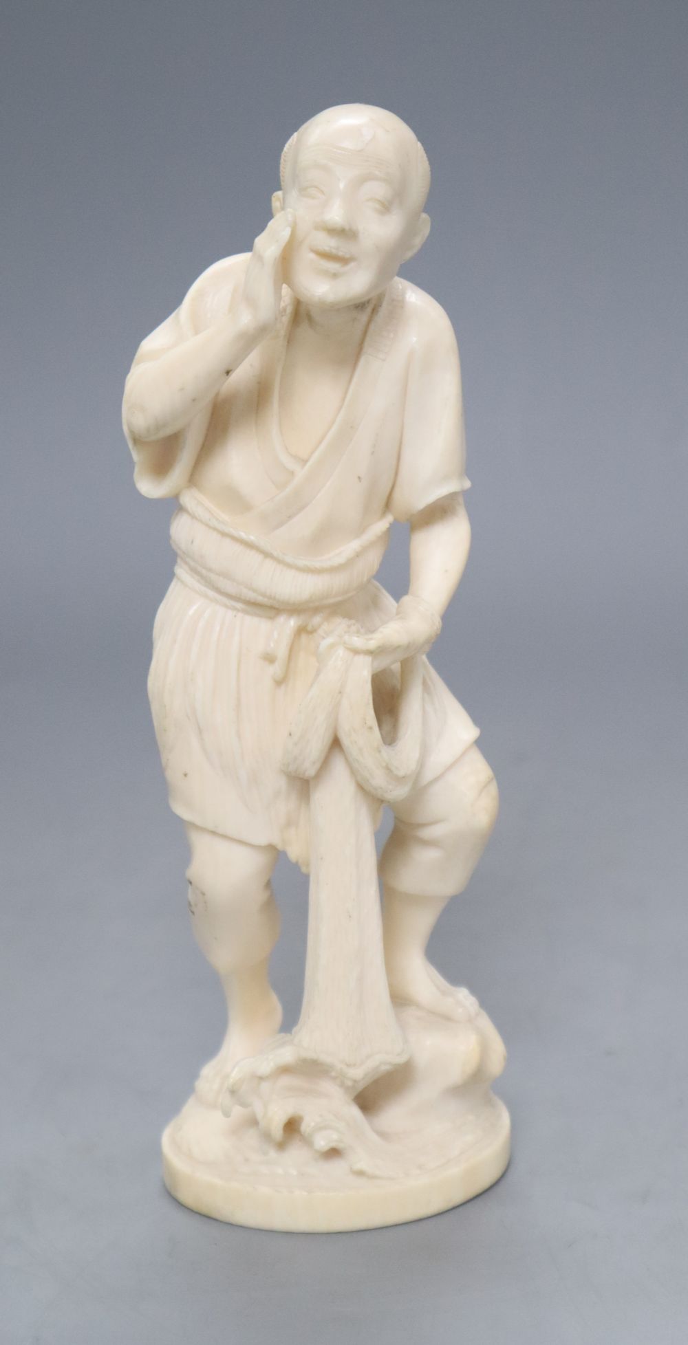 A Japanese Tokyo School carved ivory figure of a fisherman, signed, height 19cm